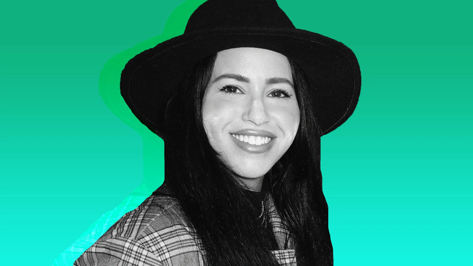 Black and white image of a person smiling, wearing a wide-brimmed hat and patterned jacket, set against a vibrant teal background.